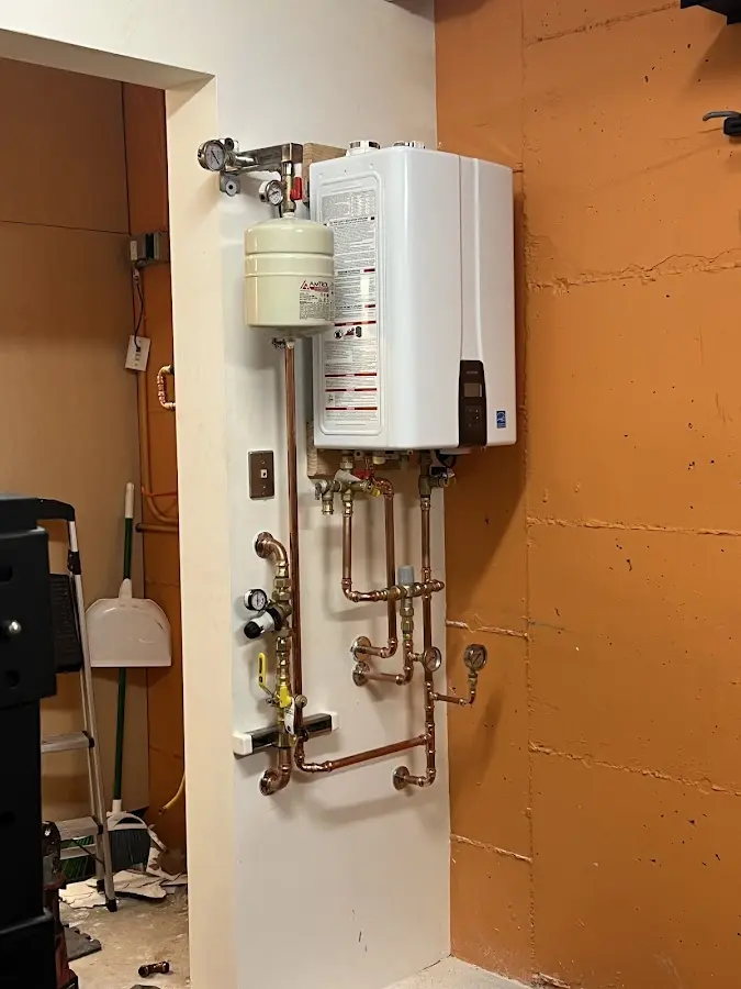 Plumbing technician inspecting water heater connections in Los Osos
